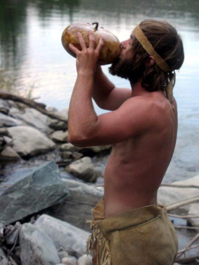 Drinking water from a gourd.