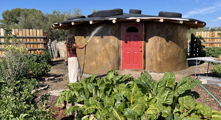 Watering fresh stucco work on the tire palace.